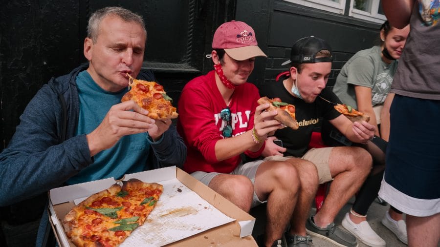 Phil Rosenthal enjoys some pizza wih some locals at Angelo's Pizza in Philadelphia Pa. on the Netflix series Sombody Feed Phil